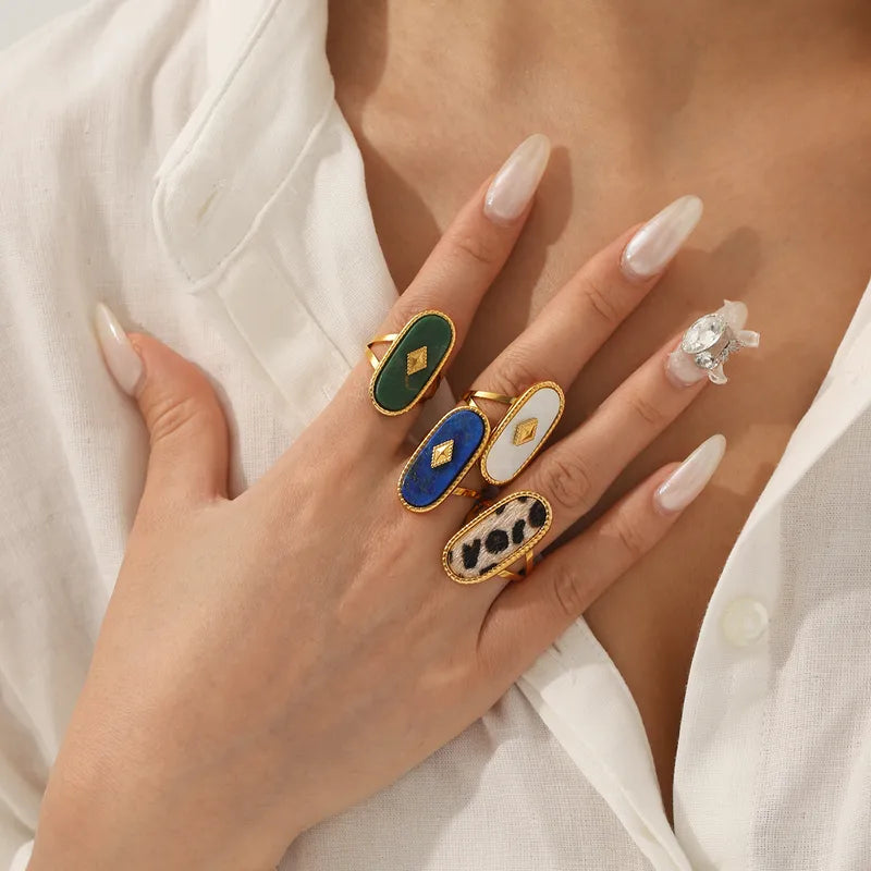 Ajoutez une note de mystère et d’élégance à votre look avec cette bague dorée sertie d’un Lapis Lazuli. Sa forme ovale allongée sublimée par une monture finement travaillée et un motif central doré en losange évoque un style à la fois bohème et sophistiqué.