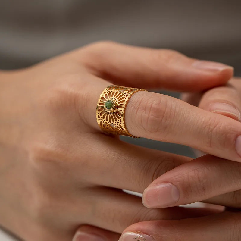 Affichez une allure solaire avec cette bague dorée ajourée en acier inoxydable, inspirée d’une rosace orientale. Son design dentelé finement découpé entoure une pierre verte centrale, pour un effet à la fois précieux et lumineux.