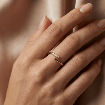 Bague dorée à l’or 18k ouverte, sertie de trois pierres blanches, design épuré, diamètre 1,7 cm, usage quotidien