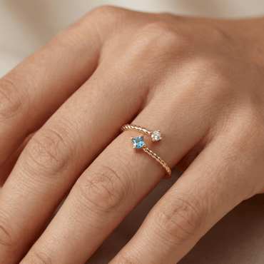 Bague dorée à l’or 18k torsadée, sertie de deux pierres blanche et bleue, design ouvert, élégante pour un usage quotidien
