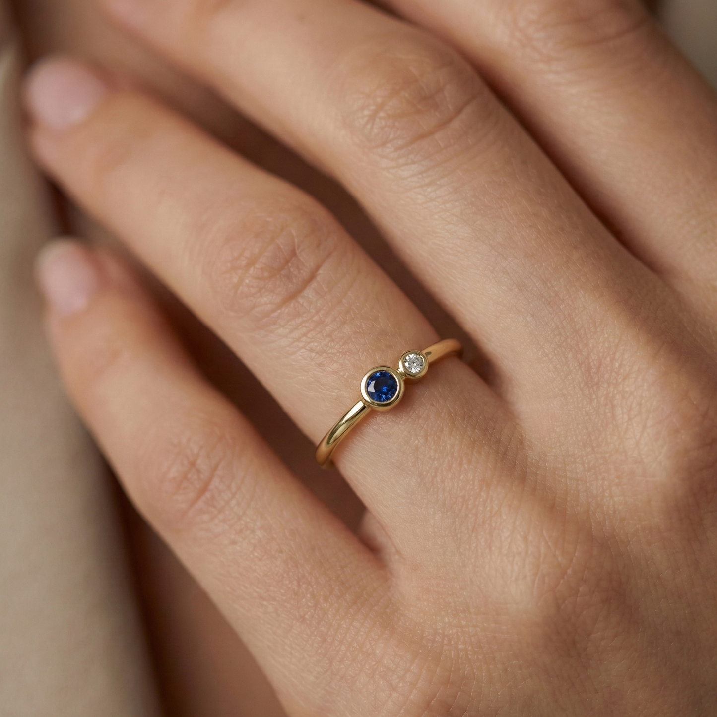 Bague dorée or 18k fine avec pierre bleue ronde et zircon blanc décentrés