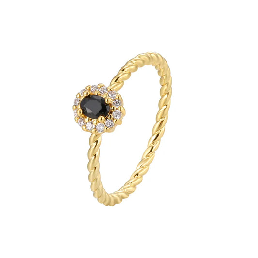 Bague dorée or 18K pour femme, ornée d’une pierre noire facettée entourée de zircons blancs sur un anneau torsadé raffiné, au style chic, féminin et intemporel, alliant contraste et élégance moderne.