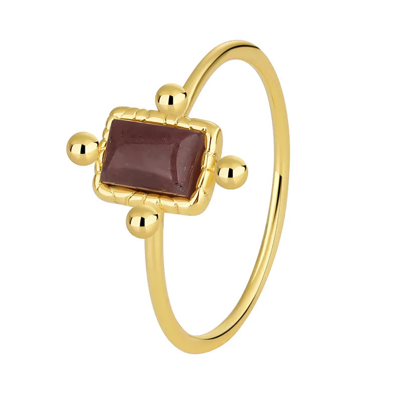 Bague plaqué or avec pierre rectangulaire prune foncé et quatre billes décoratives, au style antique et bohème chic, raffinée et pleine de caractère.
