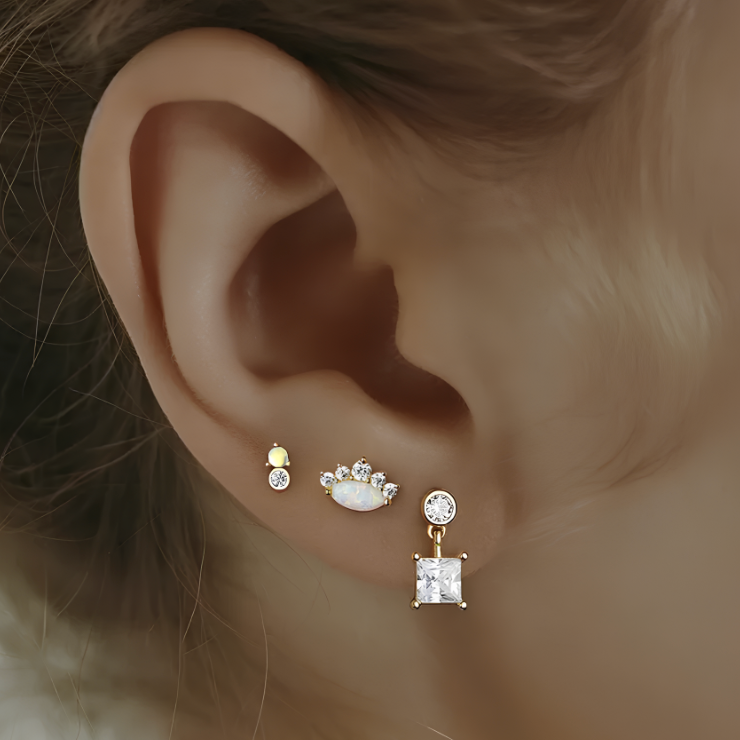 Ajoutez une touche d'élégance et de mystère à votre look avec cette boucle d'oreille unique en argent 925 doré à l'or fin, ornée d'une somptueuse opale et d'un éclatant zircon. L'opale, avec ses reflets chatoyants et colorés, est magnifiquement mise en valeur par le zircon brillant, créant un contraste subtil et raffiné. L'argent 925 doré à l'or fin apporte une finition luxueuse et intemporelle, garantissant un bijou à la fois durable et élégant, parfait pour toute occasion.