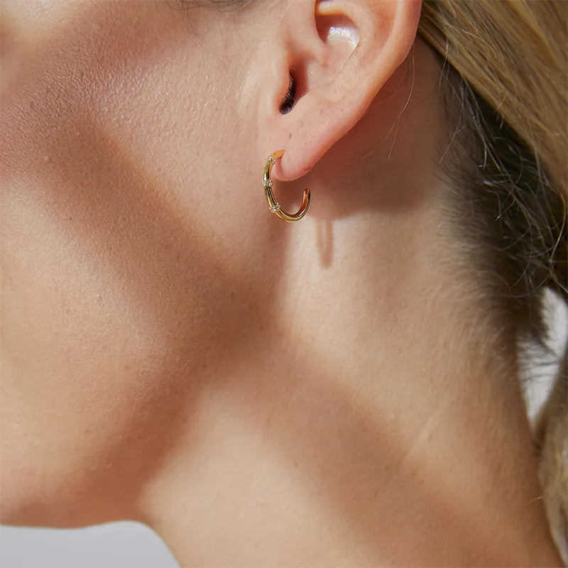 Boucles d’oreilles créoles dorées pour femme en plaqué or, ornées de trois fines lignes de zircons étincelants. Bijou moderne et raffiné, au design fluide et épuré, parfait pour une allure chic et lumineuse au quotidien ou en soirée