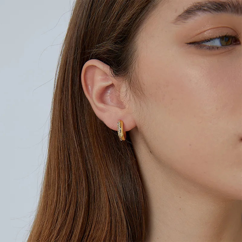 Boucles d’oreilles créoles dorées épaisses pour femme en plaqué or, ornées d’une ligne de zircons scintillants sur la face extérieure. Bijou chic et intemporel, au style minimaliste et luxueux, parfait pour illuminer un look de jour ou de soirée avec élégance.