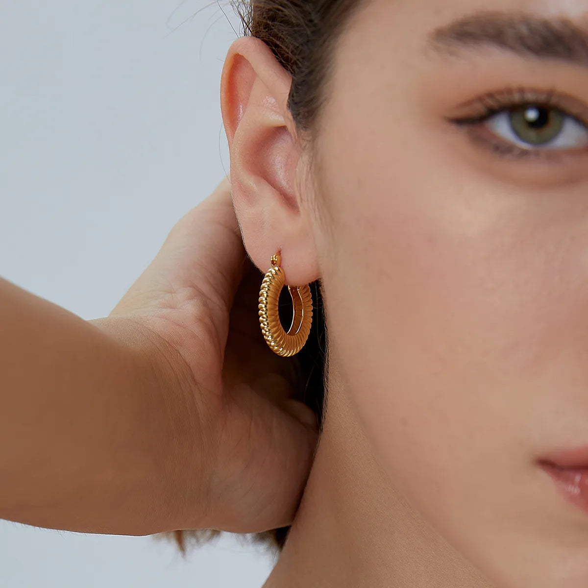 Boucles d’oreilles créoles dorées pour femme en plaqué or, à texture ondulée et finition brillante. Bijou statement inspiré des années 80, au style rétro-chic et glamour, parfait pour sublimer une tenue sobre ou un look moderne audacieux