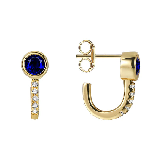 Boucles d’oreilles demi-créoles dorées pour femme en plaqué or, ornées d’un zircon bleu intense et de zircons blancs étincelants sur la courbe inférieure. Bijou chic et contemporain, raffiné et lumineux, parfait pour un look élégant au quotidien ou en soirée