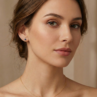 Boucles d'oreilles puces en argent doré avec pierre zircon couleur saphir bleu roi, style joaillerie élégant.