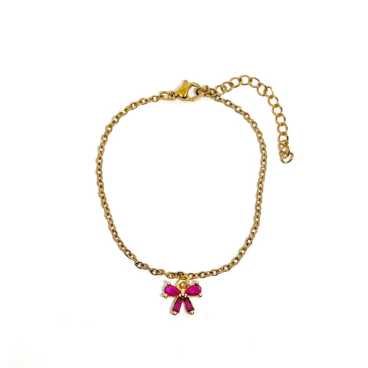 Bracelet femme en acier inoxydable couleur doré, orné d’un petit nœud serti de pierres roses façon grenat. Bijou fin, romantique et ajustable, hypoallergénique et résistant à l’eau, parfait pour un look féminin et raffiné