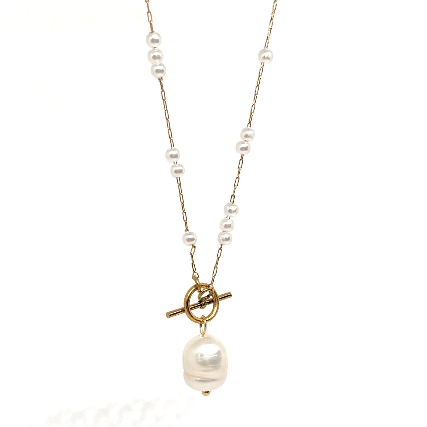 Collier doré pour femme en acier inoxydable, orné de perles blanches et d’un pendentif perle baroque suspendu à un fermoir toggle décoratif. Bijou raffiné, résistant à l’eau, au style chic et romantique idéal pour une tenue élégante ou bohème
