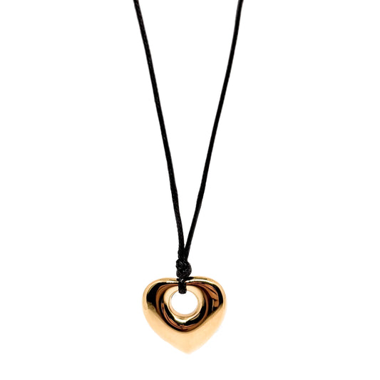 Collier long pour femme avec pendentif cœur doré en acier inoxydable suspendu à un cordon noir. Bijou moderne et graphique, au design massif et miroir, idéal pour un look audacieux et contemporain