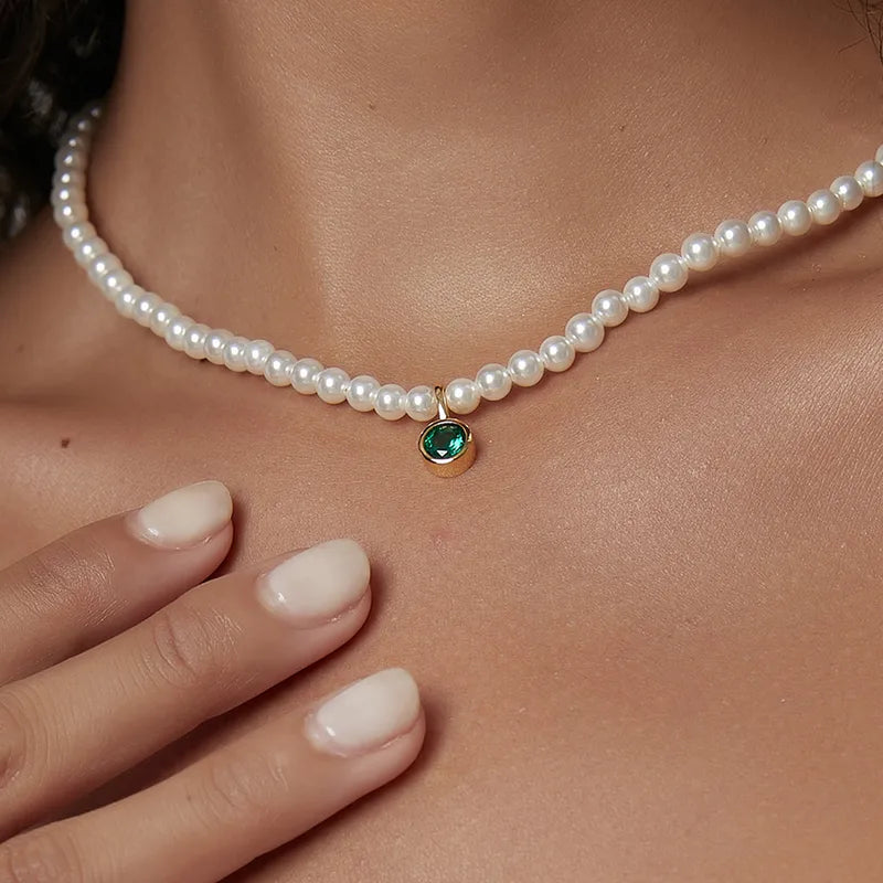 collier femme de perles blanches orné d’un pendentif rond en pierre verte émeraude facettée cerclée de doré, longueur ajustable 40 à 45 cm, bijou intemporel et audacieux au charme élégant