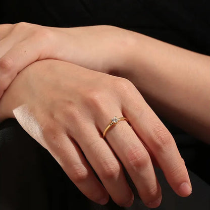 Bague dorée or 18K pour femme, ornée d’un zircon blanc en forme de cœur accompagné de deux pierres latérales scintillantes, au style romantique, minimaliste et raffiné, parfaite comme bague de promesse ou cadeau d’amour.