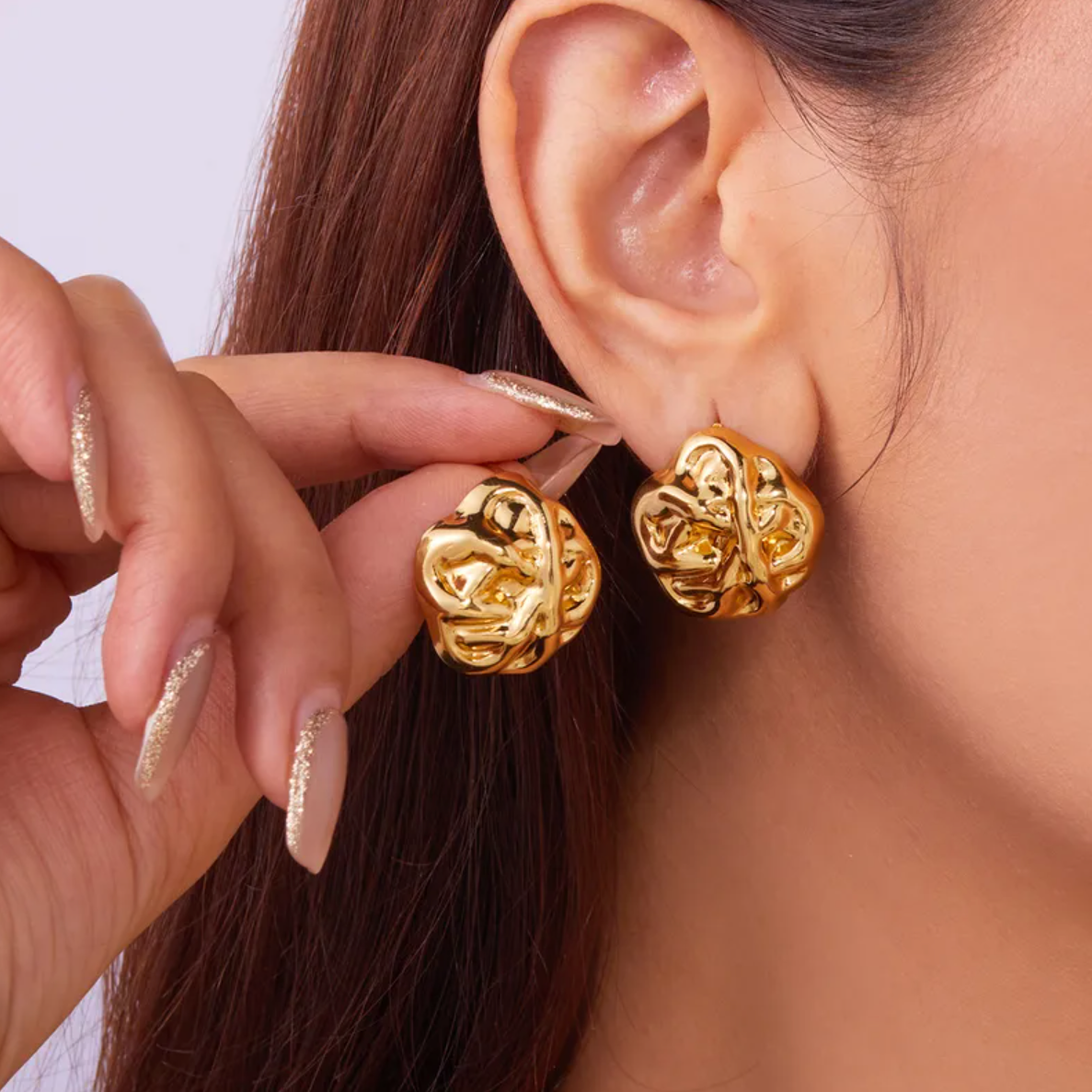 Boucles d’oreilles puces à la forme libre et organique, évoquant un galet martelé ou une fleur abstraite. Leur surface brillante et irrégulière crée un jeu de lumière saisissant, pour une allure forte et arty.

Matériau : Acier inoxydable couleur doré, finition lustrée, résistant à l’eau, hypoallergénique, sans ternissure.

Dimensions : 22 x 22 mm – poids : 10 g la paire.

Design : Motif sculptural irrégulier, à l’effet visuel puissant, façon bijou d’artiste. Fermeture clou classique au dos.

Style : Parfai