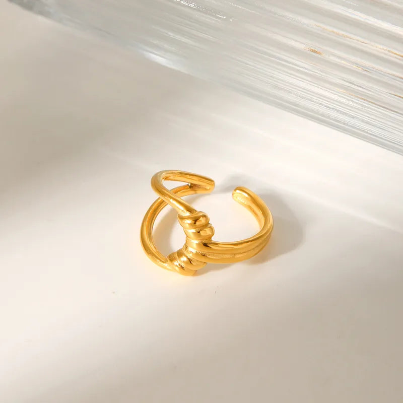 Affirmez un style audacieux et structuré avec cette bague dorée en acier inoxydable, inspirée d’un nœud sculptural. Un design moderne, à la fois minimaliste et imposant, qui capte la lumière avec intensité.