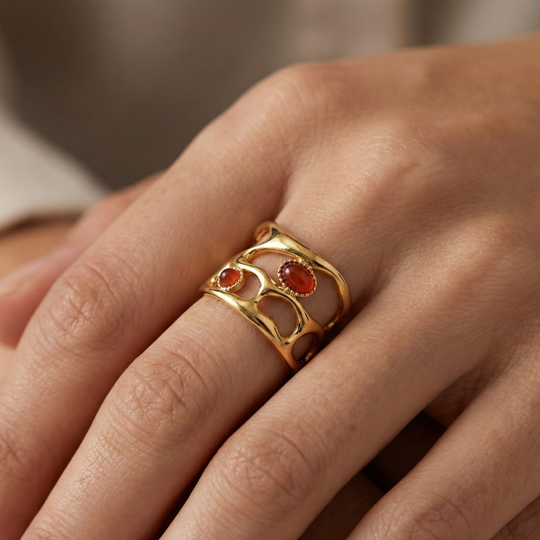 Bague acier inoxydable doré agate rouge portée sur doigt