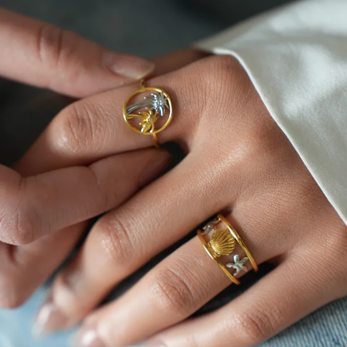 Inspirée des trésors de l’océan, cette bague dorée ajustable met en scène une coquille Saint-Jacques centrale, encadrée de deux étoiles de mer argentées, pour un look solaire et estival. Son design ouvert apporte une touche de légèreté et permet un ajustement facile à tous les doigts.

Conçue en acier inoxydable couleur doré, ce bijou est résistant à l’eau, hypoallergénique, et ne ternit pas. Parfaite pour un port quotidien, même à la plage.

Matériaux : Acier inoxydable doré et argenté
Dimensions : 1,75 cm