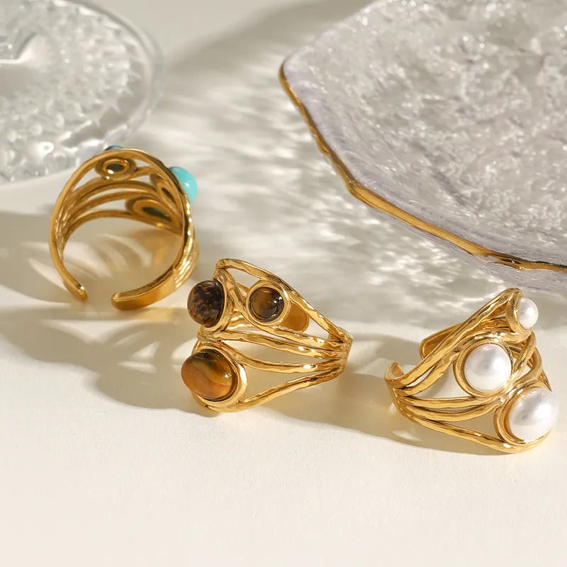 Ajoutez une touche de caractère et d’énergie à votre look avec cette bague en acier inoxydable doré ornée de trois perles en œil de tigre. Chaque pierre naturelle est unique, aux reflets chauds et profonds, sublimée par un design texturé aux lignes entrelacées.
