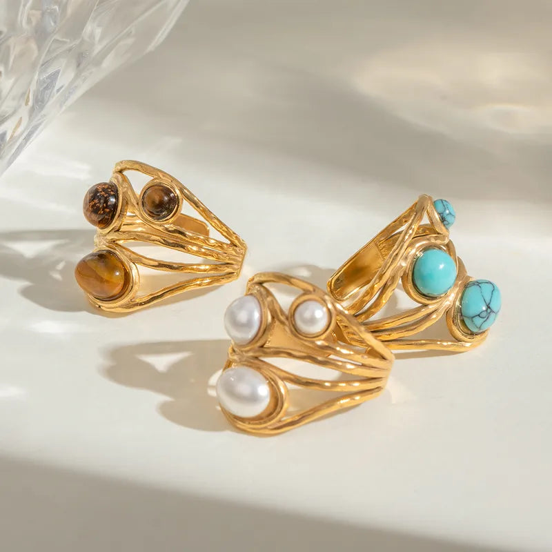 Ajoutez une touche de caractère et d’énergie à votre look avec cette bague en acier inoxydable doré ornée de trois perles en œil de tigre. Chaque pierre naturelle est unique, aux reflets chauds et profonds, sublimée par un design texturé aux lignes entrelacées.
