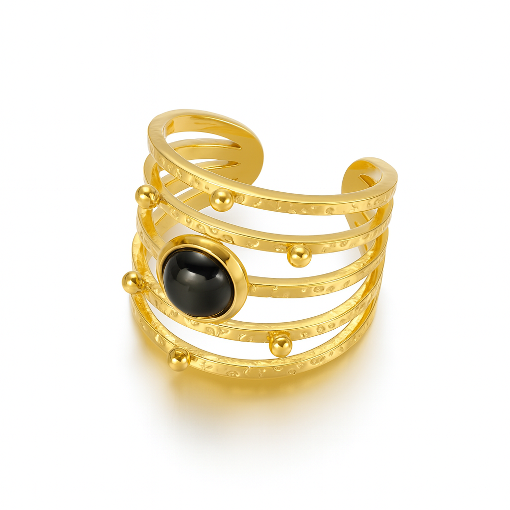 bague dorée ajourée à l’architecture moderne, composée de cinq anneaux texturés reliés entre eux, ponctués de petites sphères dorées et ornée d’une pierre noire centrale. Un bijou à la fois audacieux et élégant, parfait pour sublimer vos tenues avec caractère.