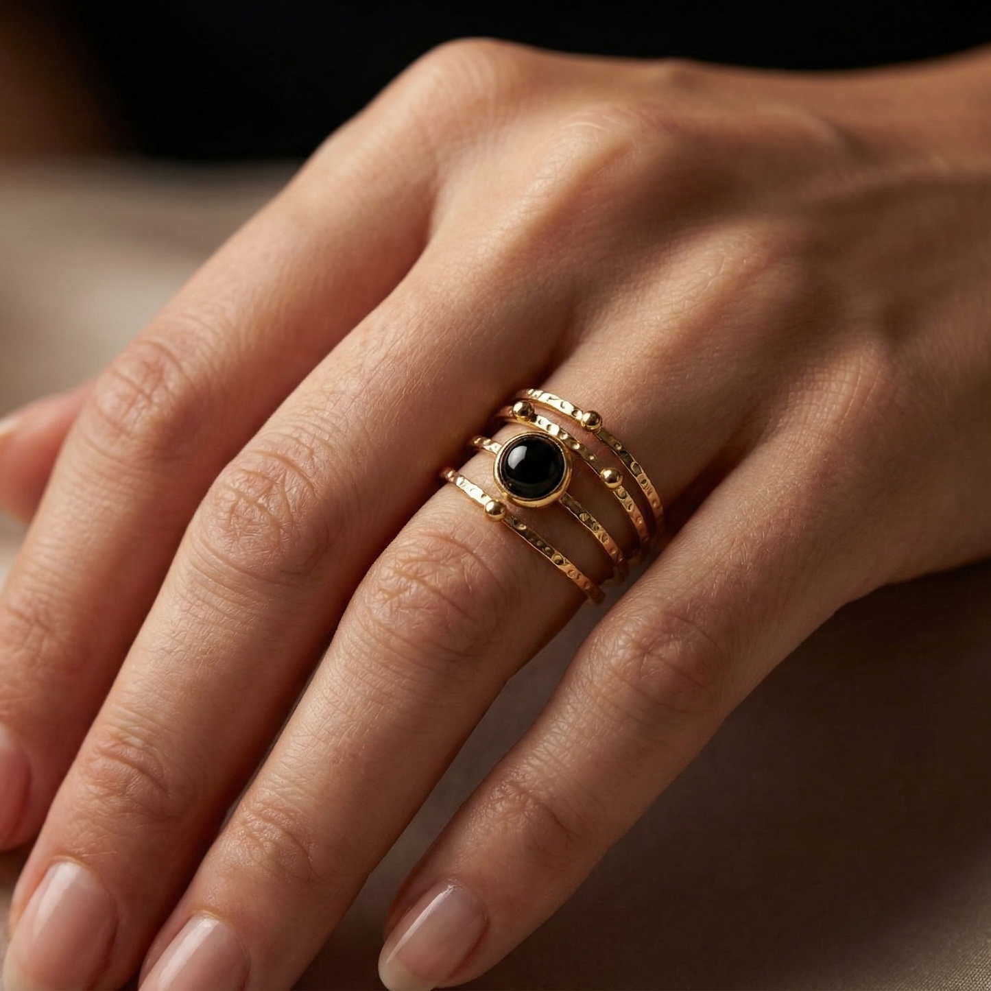 Bague acier inoxydable doré strates pierre noire portée sur doigt