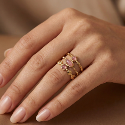 Bague acier inoxydable doré triple anneau pierres roses portée sur doigt