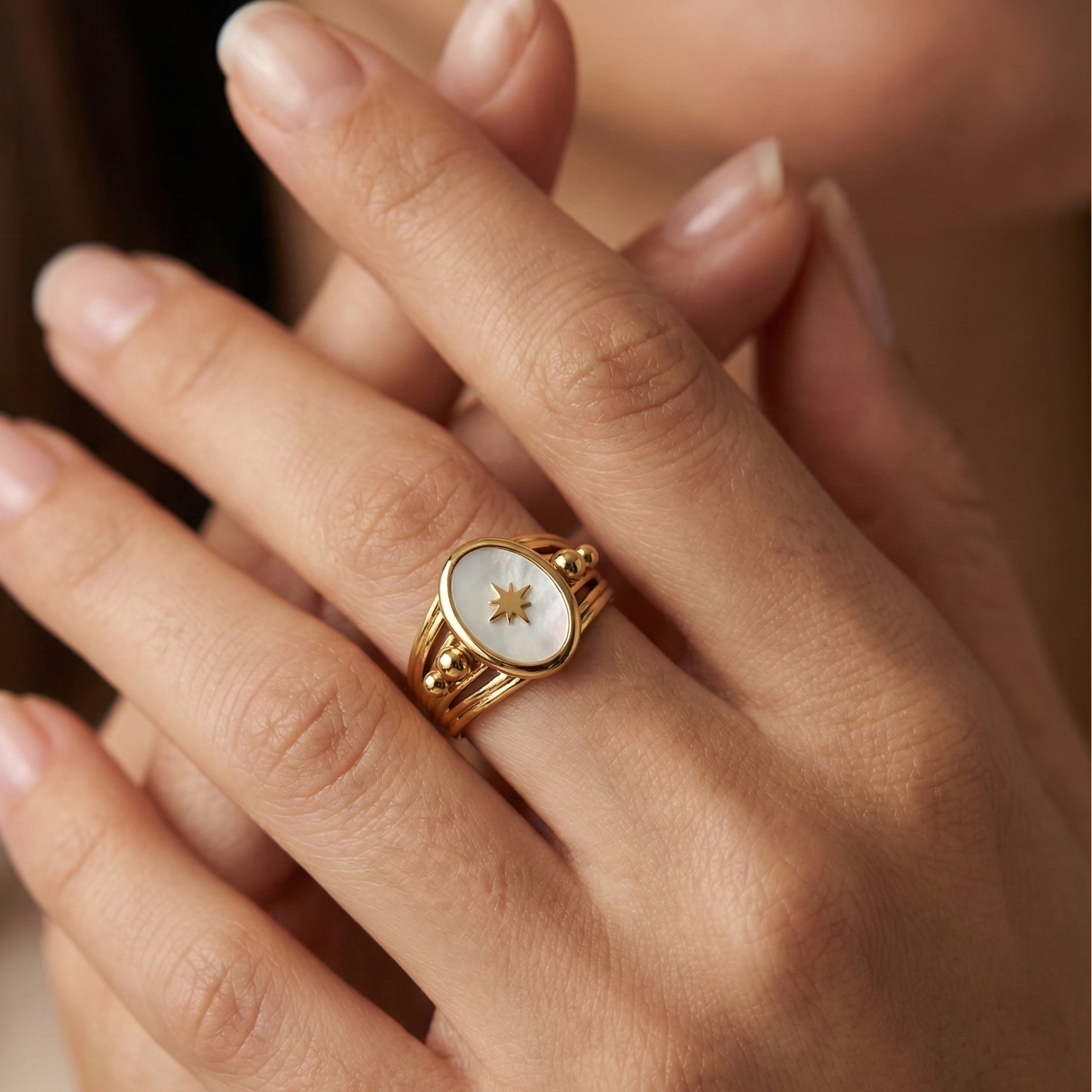 Bague acier inoxydable étoile dorée centre nacre portée sur doigt