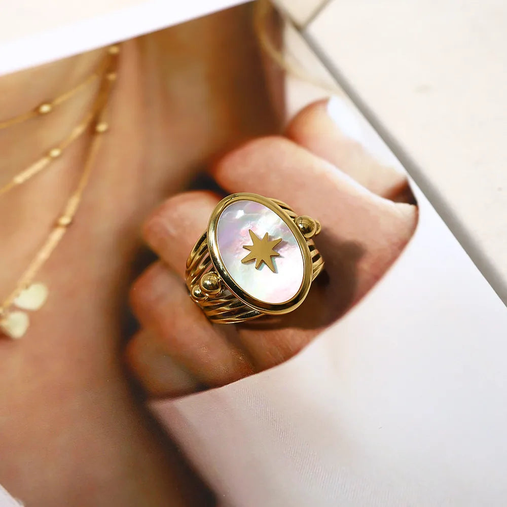 Découvrez l’élégance intemporelle de cette bague, conçue pour captiver tous les regards. Son design raffiné met en valeur un somptueux centre pièce en nacre ovale rehaussé d’une étoile dorée délicatement incrustée, symbolisant lumière et sophistication.