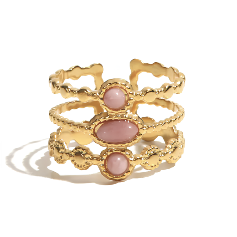 Craquez pour l’élégance de cette bague dorée à effet triple anneau, délicatement sertie de trois pierres roses aux reflets nacrés. Sa structure perlée et ajourée lui confère un charme rétro et romantique, parfait pour sublimer vos tenues avec une touche poétique et raffinée.