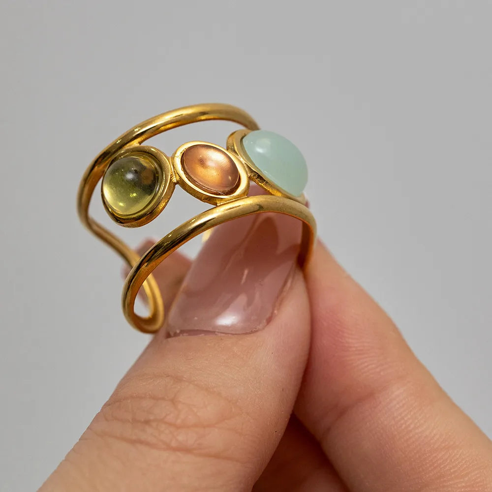 Ajoutez une touche de couleur et d’élégance à votre look avec cette bague dorée multicolore au design audacieux. Sa monture en acier inoxydable doré accueille&nbsp;trois perles lisses aux teintes douces et lumineuses : jaune pastel, bleu ciel, et cuivre. Un bijou original qui attire les regards tout en restant raffiné.

Design : Bague ouverte moderne avec pierres colorées cabochon.