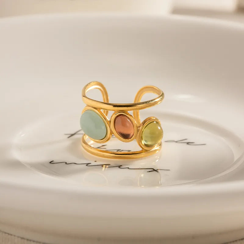 Ajoutez une touche de couleur et d’élégance à votre look avec cette bague dorée multicolore au design audacieux. Sa monture en acier inoxydable doré accueille&nbsp;trois perles lisses aux teintes douces et lumineuses : jaune pastel, bleu ciel, et cuivre. Un bijou original qui attire les regards tout en restant raffiné.

Design : Bague ouverte moderne avec pierres colorées cabochon.