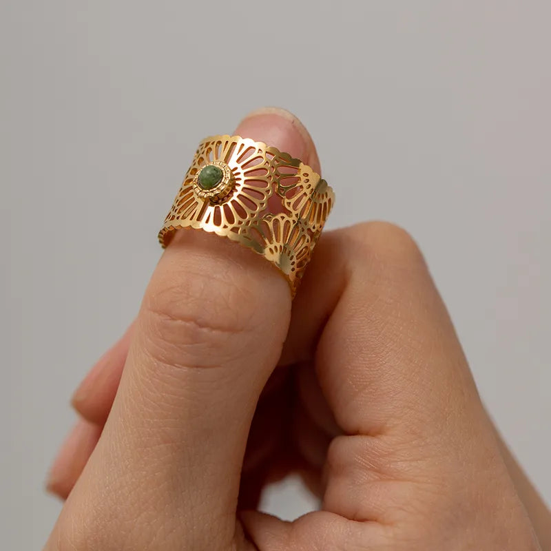 Affichez une allure solaire avec cette bague dorée ajourée en acier inoxydable, inspirée d’une rosace orientale. Son design dentelé finement découpé entoure une pierre verte centrale, pour un effet à la fois précieux et lumineux.
