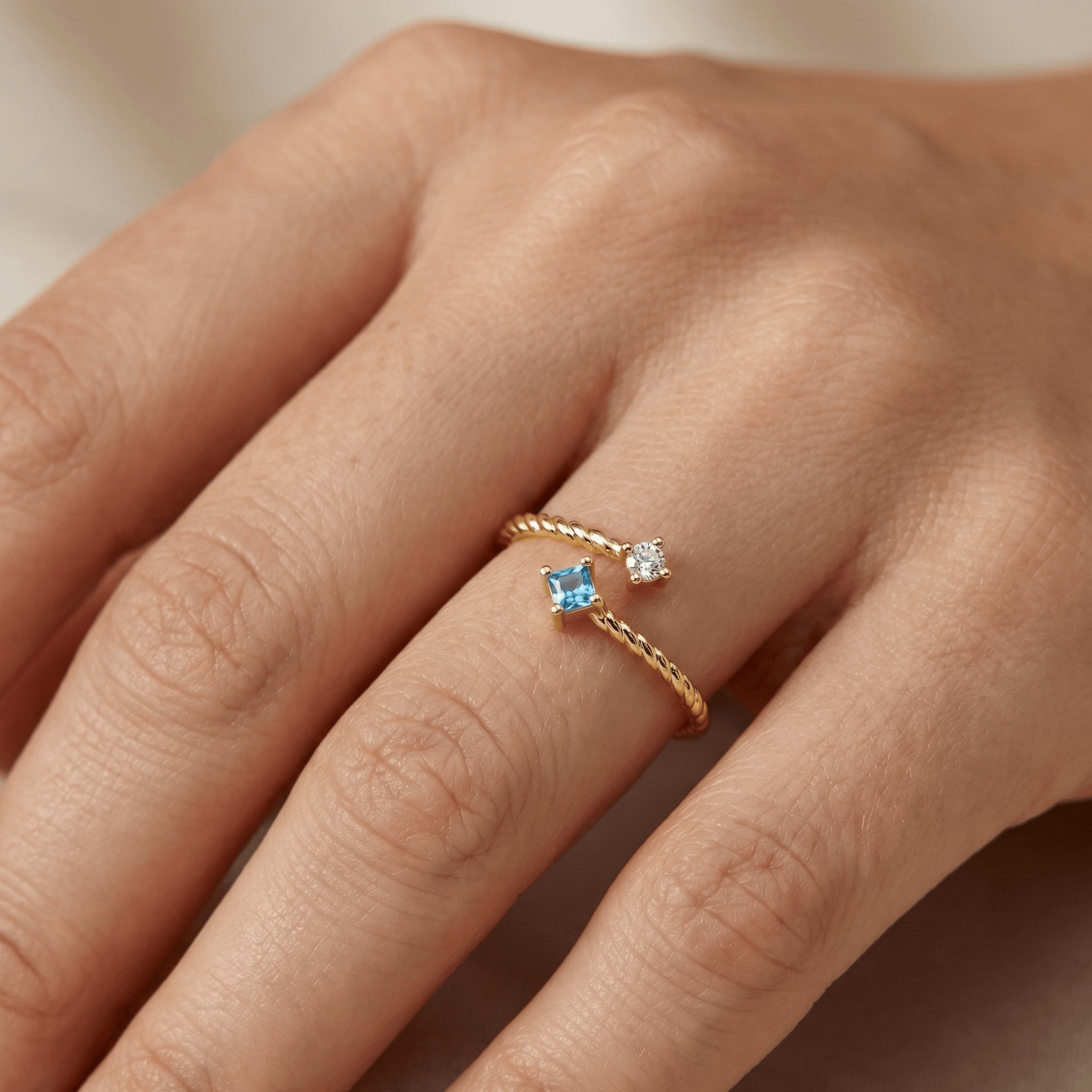 Bague dorée à l’or 18k torsadée, sertie de deux pierres blanche et bleue, design ouvert, élégante pour un usage quotidien