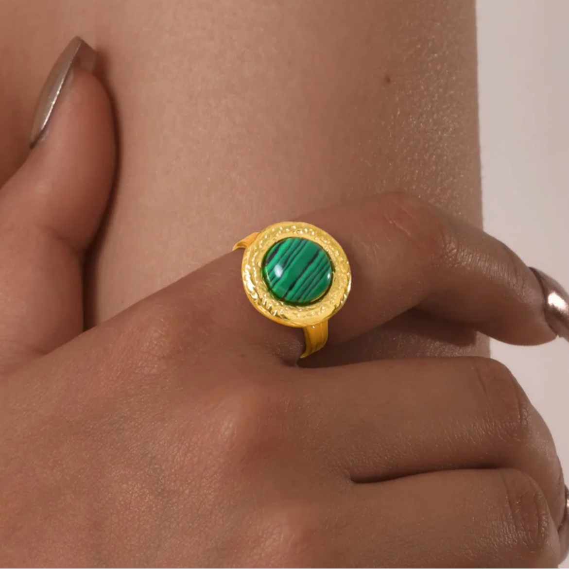 Bague audacieuse et lumineuse ornée d’une pierre marbrée verte montée sur une base dorée martelée. Un contraste saisissant entre le vert profond et l’or texturé pour un look affirmé.

Matériau : Acier inoxydable couleur doré, finition martelée. Pierre synthétique effet malachite, veinée de noir.

Dimensions : Diamètre face : 1,68 cm. Taille ajustable. Poids : 6 g.

Design : Forme arrondie vintage, texture irrégulière effet forgé. La pierre verte est bombée, lisse, et captivante.

Style : Idéale pour ajouter