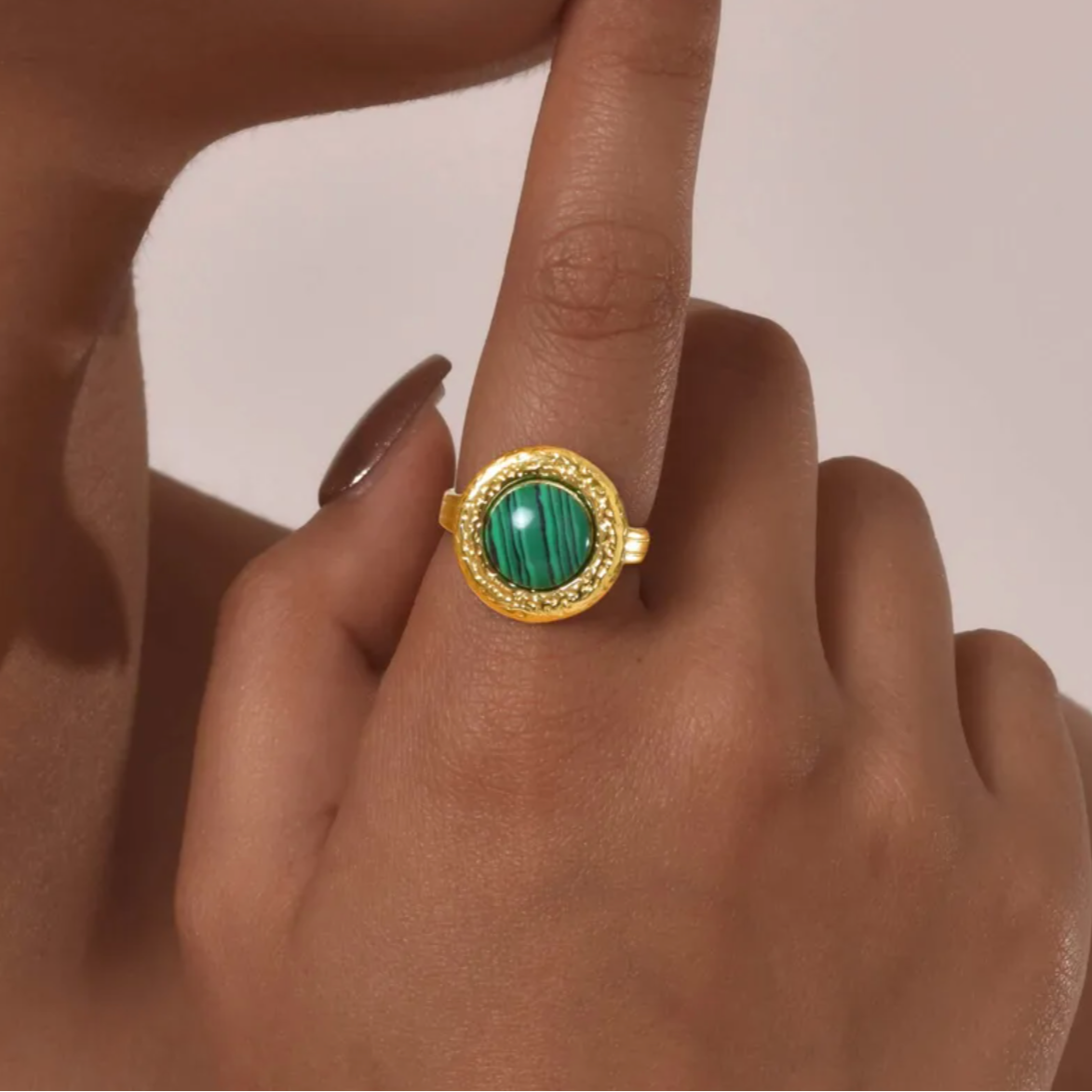 Bague audacieuse et lumineuse ornée d’une pierre marbrée verte montée sur une base dorée martelée. Un contraste saisissant entre le vert profond et l’or texturé pour un look affirmé.

Matériau : Acier inoxydable couleur doré, finition martelée. Pierre synthétique effet malachite, veinée de noir.

Dimensions : Diamètre face : 1,68 cm. Taille ajustable. Poids : 6 g.

Design : Forme arrondie vintage, texture irrégulière effet forgé. La pierre verte est bombée, lisse, et captivante.

Style : Idéale pour ajouter