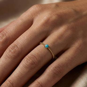 Bague dorée or 18k à anneau perlée avec pierre turquoise facettée centrale, bijou fin et lumineux