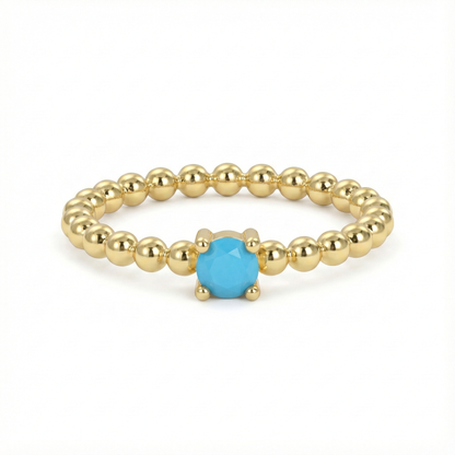 Bague dorée or 18k à anneau perlée avec pierre turquoise facettée centrale, bijou fin et lumineux