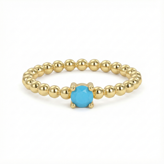 Bague dorée or 18k à anneau perlée avec pierre turquoise facettée centrale, bijou fin et lumineux