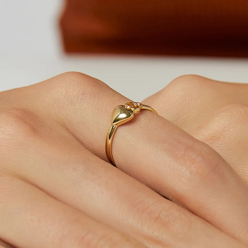 Bague dorée or 18K pour femme, ornée d’un motif double cœur composé d’un cœur plein satiné et d’un cœur ajouré serti de zircons blancs, au style romantique et féminin, symbole d’amour et de tendresse éternelle.