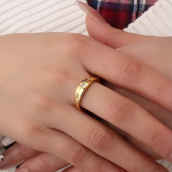 Bague dorée or 18K pour femme, ornée de trois étoiles gravées à huit branches serties de zircons scintillants, au style astral et poétique, parfaite pour un look raffiné et symbolique inspiré du ciel nocturne.