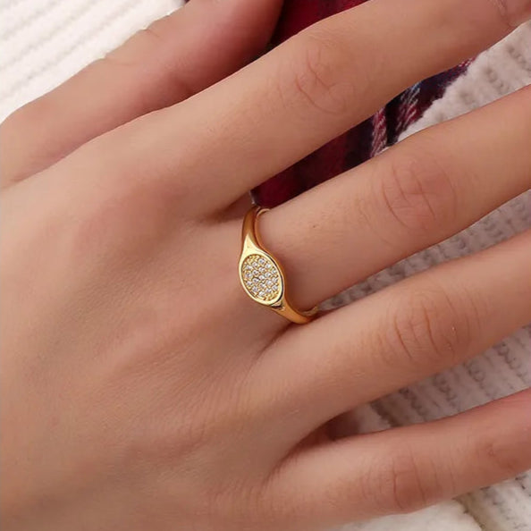 Bague dorée or 18K pour femme, à forme ovale bombée entièrement pavée de zircons scintillants, inspirée de la chevalière moderne, au style chic et lumineux pour un look raffiné et contemporain.