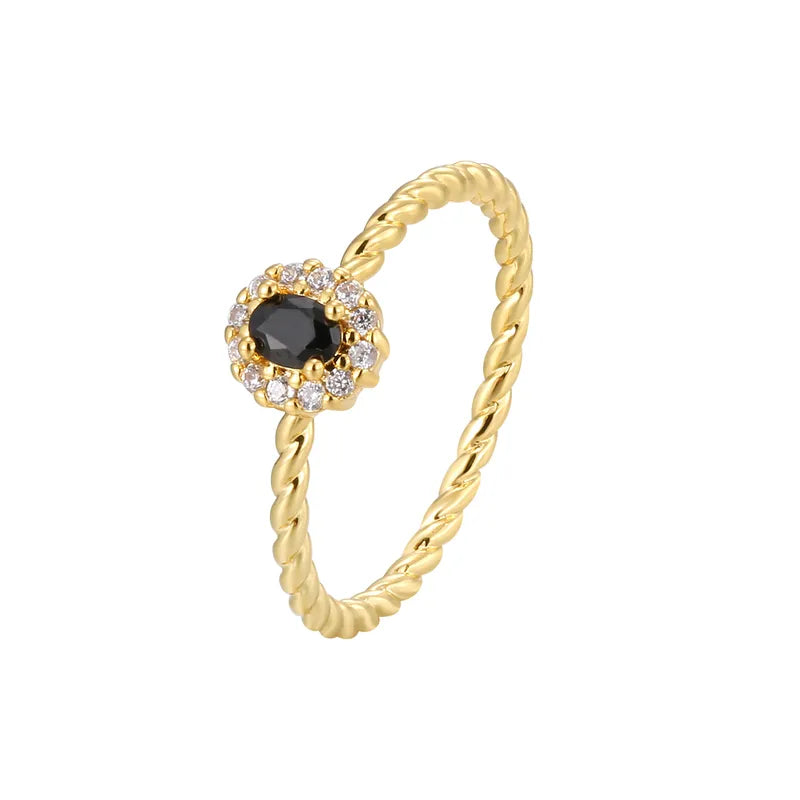 Bague dorée or 18K pour femme, ornée d’une pierre noire facettée entourée de zircons blancs sur un anneau torsadé raffiné, au style chic, féminin et intemporel, alliant contraste et élégance moderne.