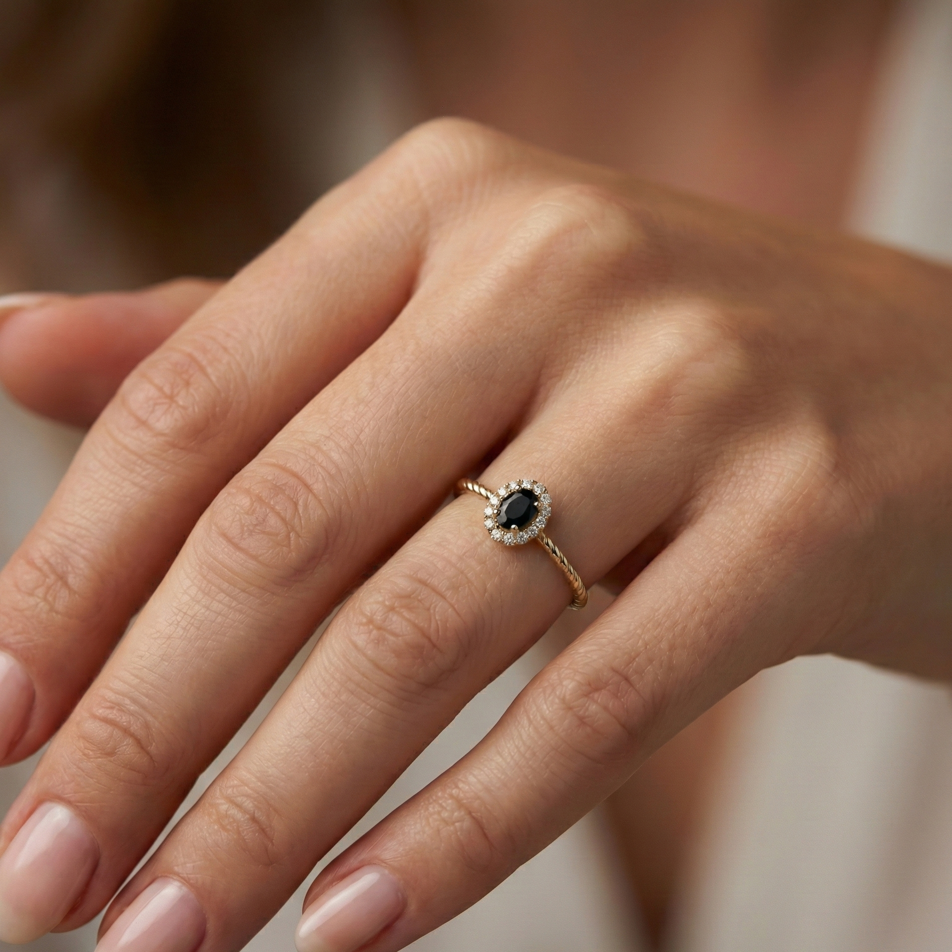 Bague dorée or 18k à anneau torsadé avec pierre noire facettée entourée de zircons blancs, bijou élégant et contrasté