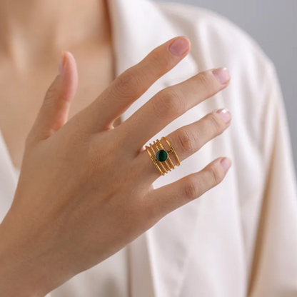 Une bague structurée en acier inoxydable doré, composée de cinq rangs perlés et ornée d’une pierre ronde verte foncée. Son style affirmé et texturé en fait un accessoire de caractère à l’élégance organique.

Matériau : Acier inoxydable couleur doré, placage PVD or 18K, cabochon vert synthétique, hypoallergénique, résistant à l’eau et à l’oxydation.

Dimensions : Diamètre 1,8 cm, taille ajustable, poids 2,1 g.

Design : Structure ouverte, composée de rangées perlées régulières, reliées par un axe central qui