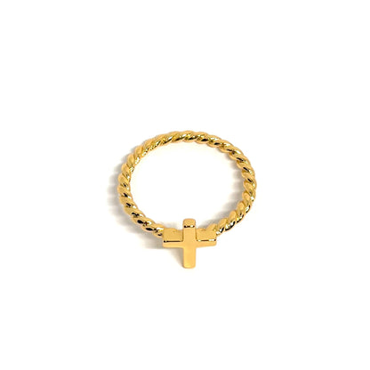 Bague femme dorée en or 18K avec croix horizontale lisse sur anneau torsadé. Bijou minimaliste et symbolique, raffiné et spirituel, parfait pour un look élégant et moderne