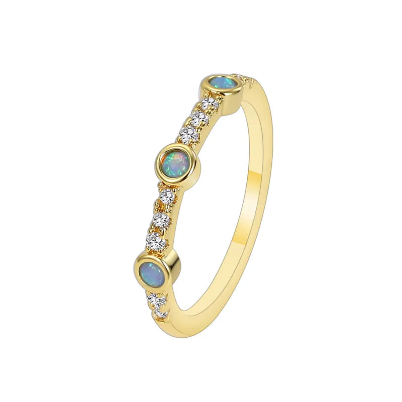 Bague femme dorée en or 18K, sertie de trois opales synthétiques irisées et de zircons blancs. Bijou raffiné au design fin et poétique, inspiré d’un halo céleste, idéal pour un look élégant et sophistiqué
