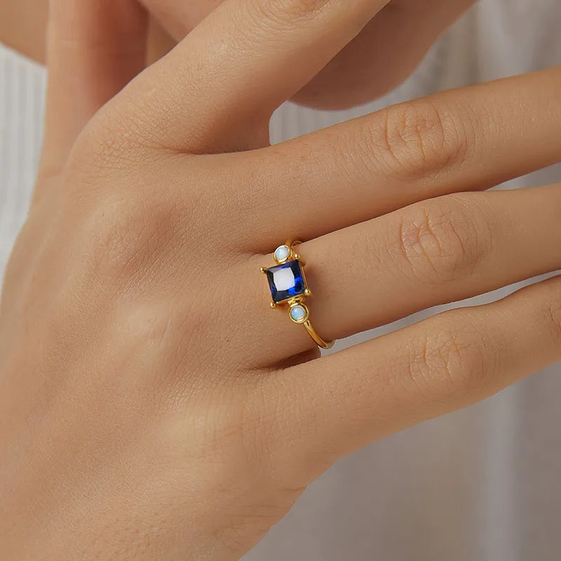 Bague femme dorée en or 18K avec pierre bleue façon saphir et opales synthétiques irisées. Bijou mystique et raffiné, inspiré des nuits étoilées, idéal pour un look élégant et spirituel