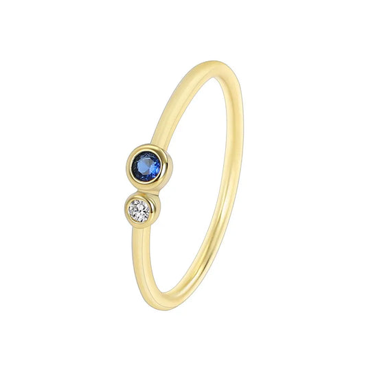 Bague femme dorée en or 18K, ornée d’une pierre bleue ronde et d’un zircon blanc étincelant. Bijou minimaliste et raffiné, inspiré de l’harmonie céleste, parfait pour un look moderne et sophistiqué