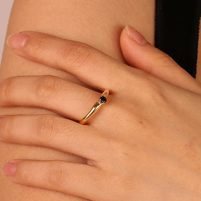 Bague femme dorée en or 18K avec pierre noire ronde facettée sertie en solitaire. Bijou minimaliste et élégant, au contraste raffiné entre doré et noir, parfait pour un style chic et intemporel